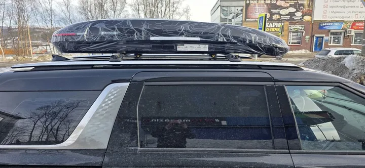 Бокс на крышу ENROAD Nomadix Pro XL Slim 400-E для Kia Carnival, цвет «Чёрный» — общий ракурс автомобиля с установленным автобоксом